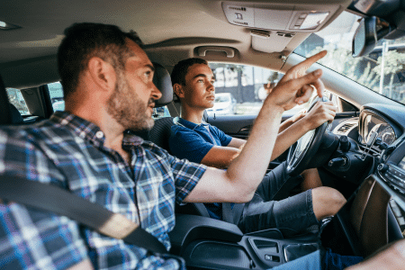 Teenager driving with his father